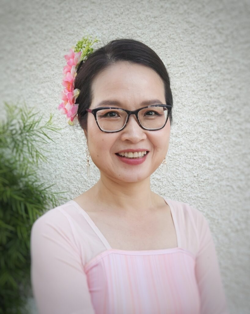 member coco wearing a flower in her hair dressed in scv chinese dance's iconic pink dress