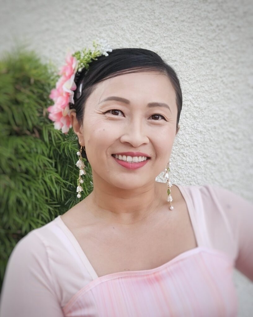 member julie wearing a flower in her hair dressed in scv chinese dance's iconic pink dress