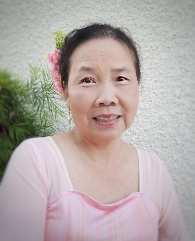 member katy wearing a flower in her hair dressed in scv chinese dance's iconic pink dress