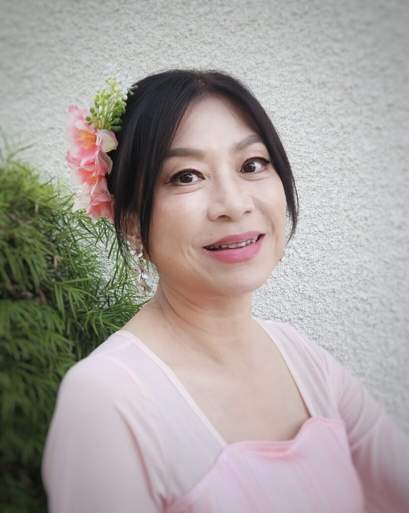 member vanessa wearing a flower in her hair dressed in scv chinese dance's iconic pink dress